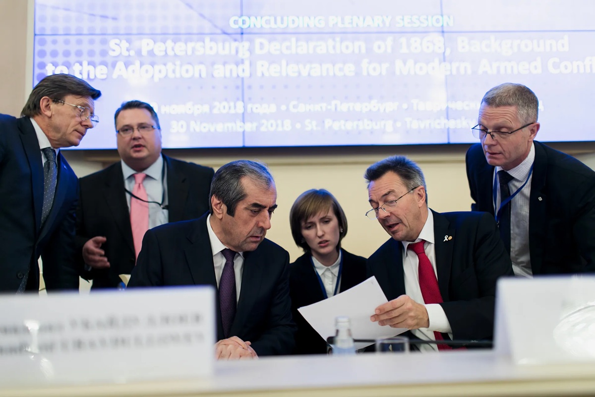 Делегаты вместе просматривают бумаги во время официальной сессии форума.