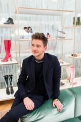 Портрет гостя, сидящего в светлом showroom-пространстве во время мероприятия.