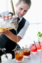 Бармен готовит напитки как часть съемки hospitality-сегмента мероприятия.